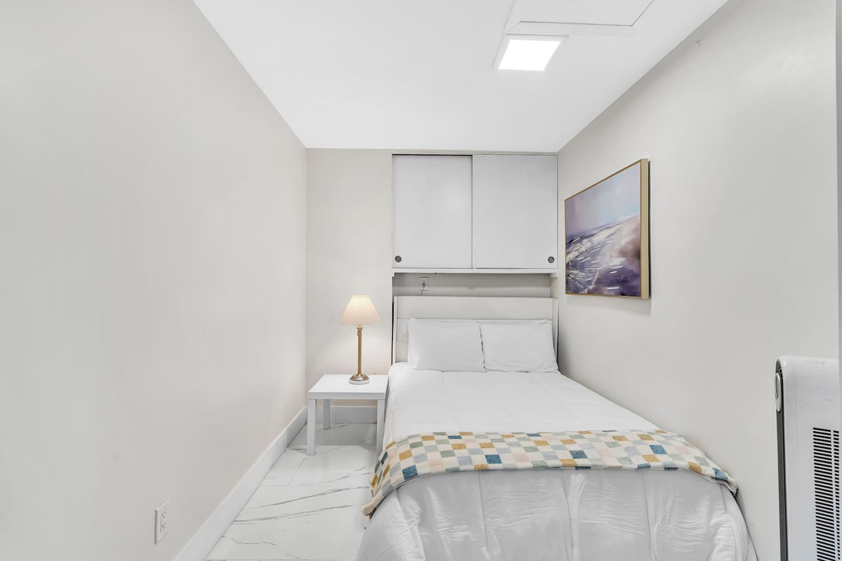 Cozy bedroom with a comfortable bed, bedside table and reading lamp.