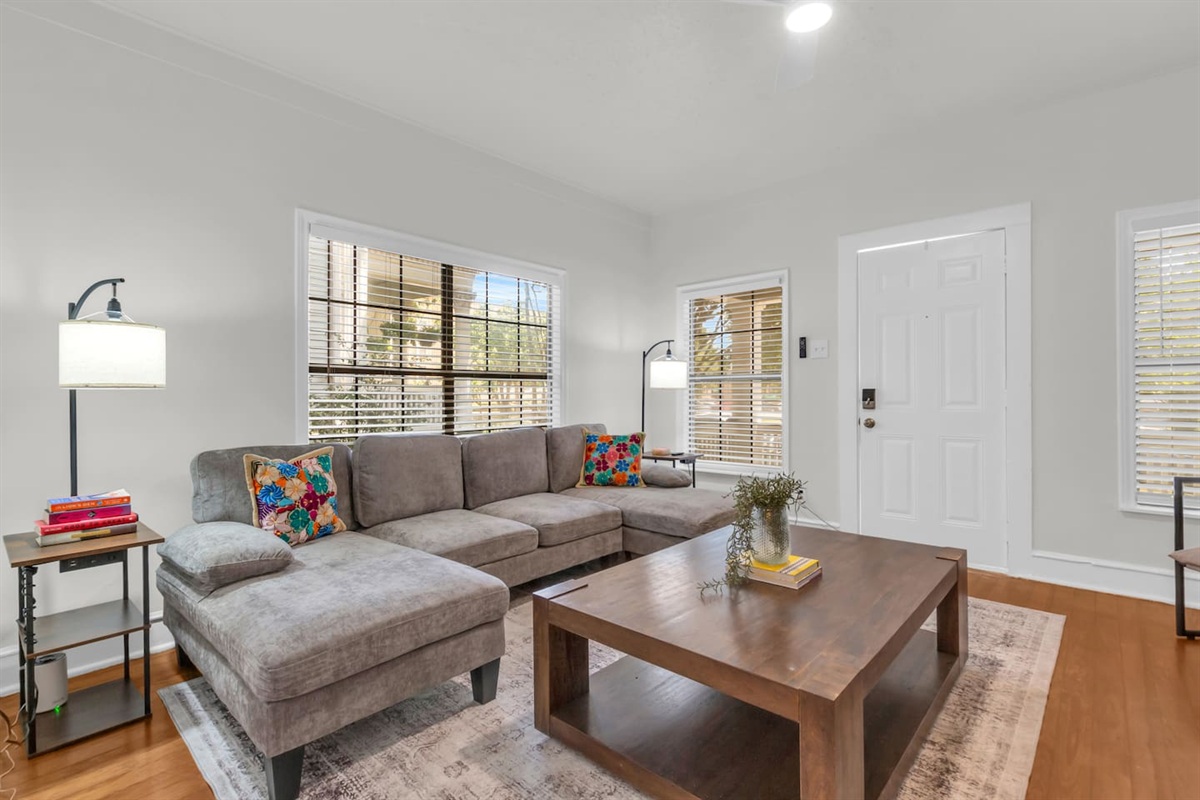 Bright living room with sectional sofa, TV,  and natural light.