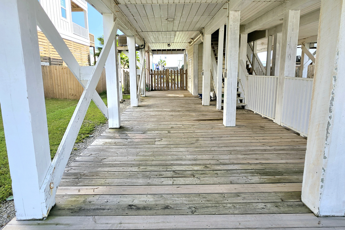 Covered under-house deck with walkway to the backyard