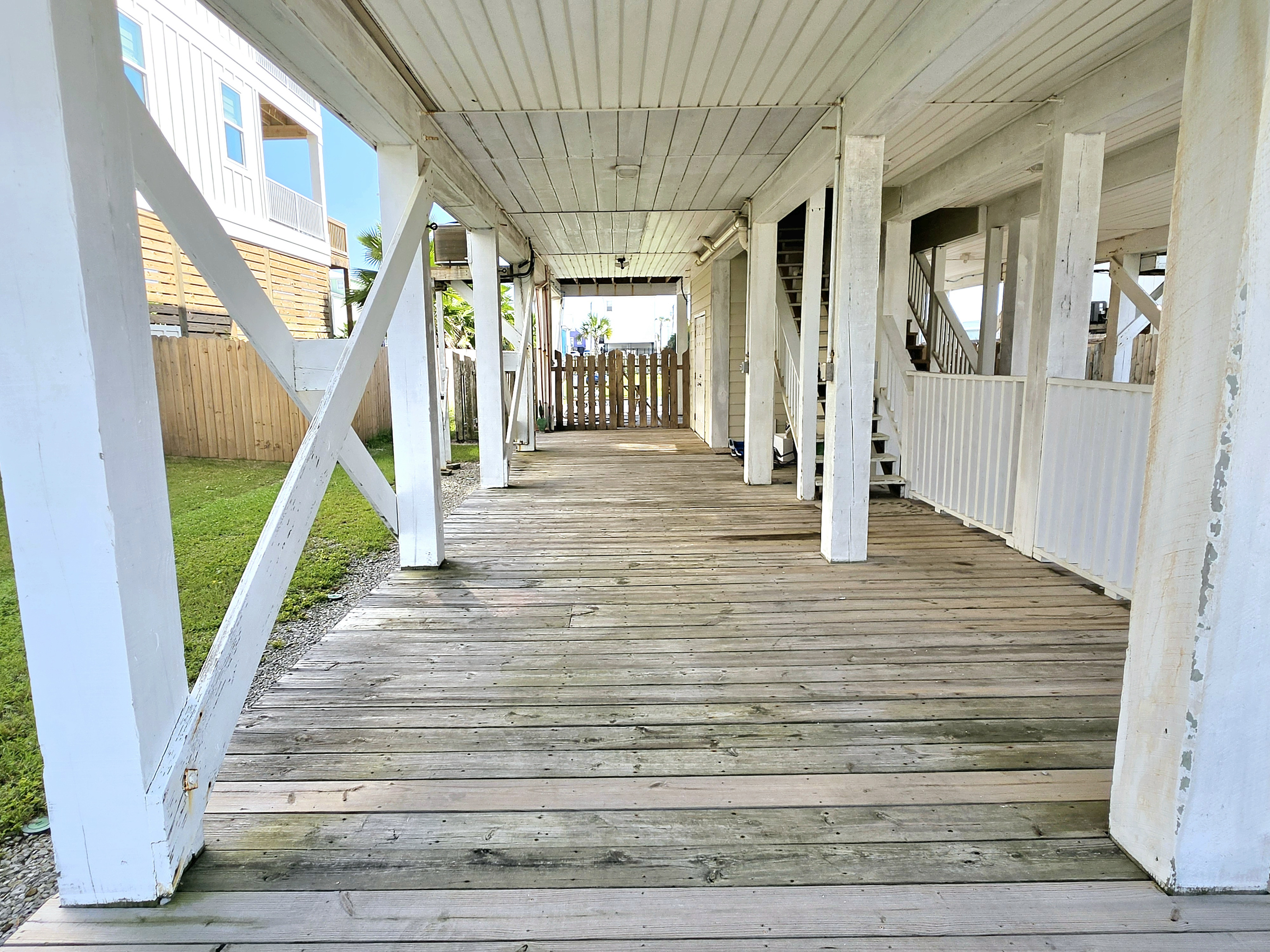 Covered under-house deck with walkway to the backyard