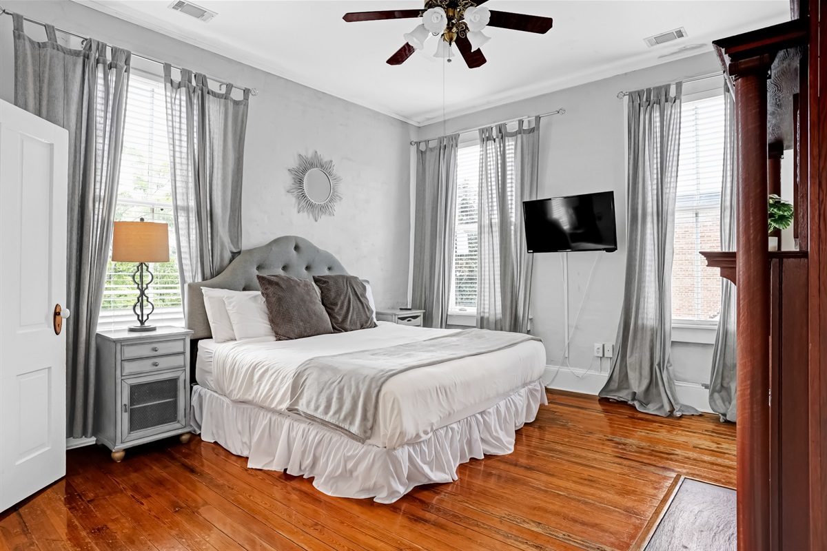 The primary suite features a plush king bed, natural light, and classic style.