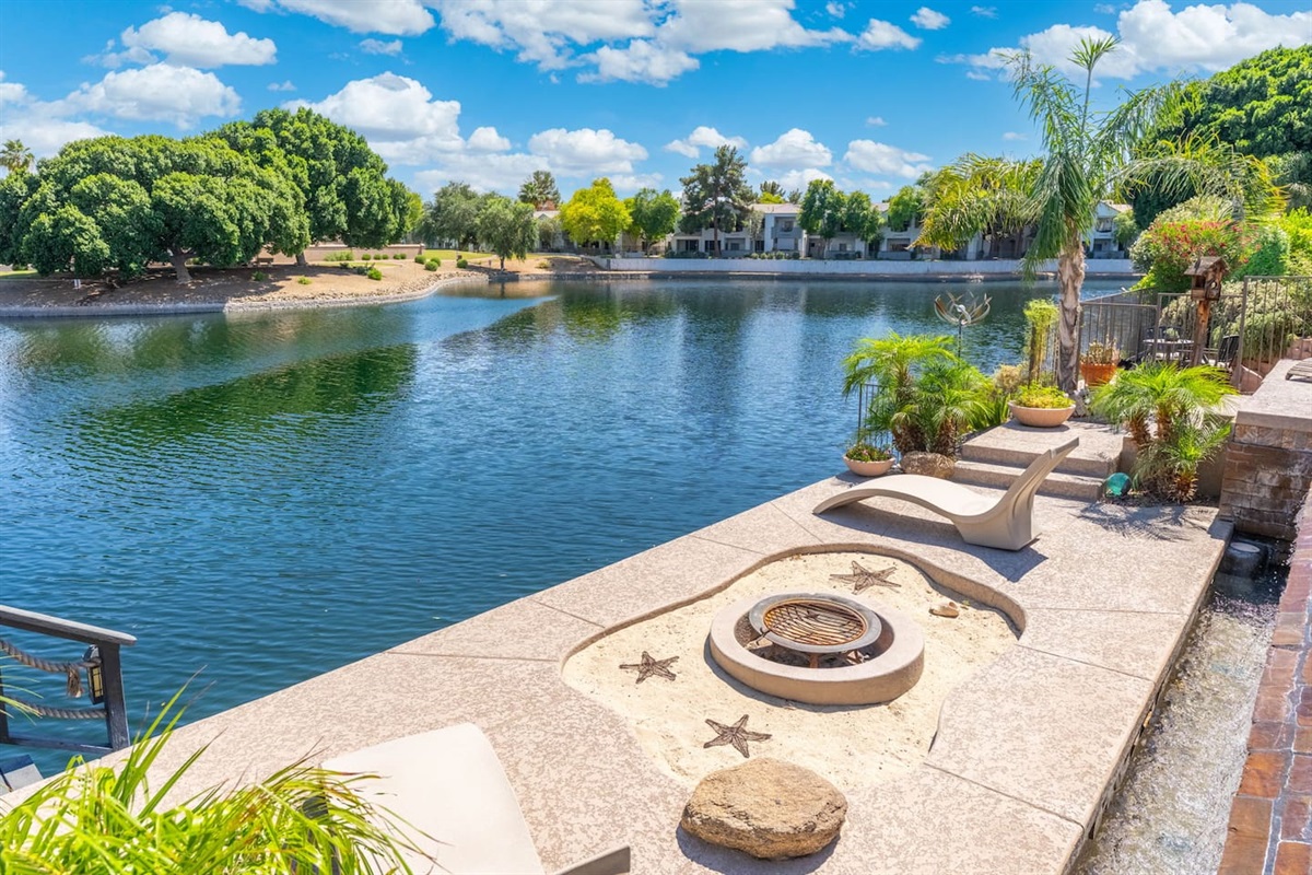 The lakeside fire pit terrace is a one-of-a-kind feature — star-accented stonework, built-in curved loungers, and an unobstructed water view make this the most memorable spot to gather after dark.