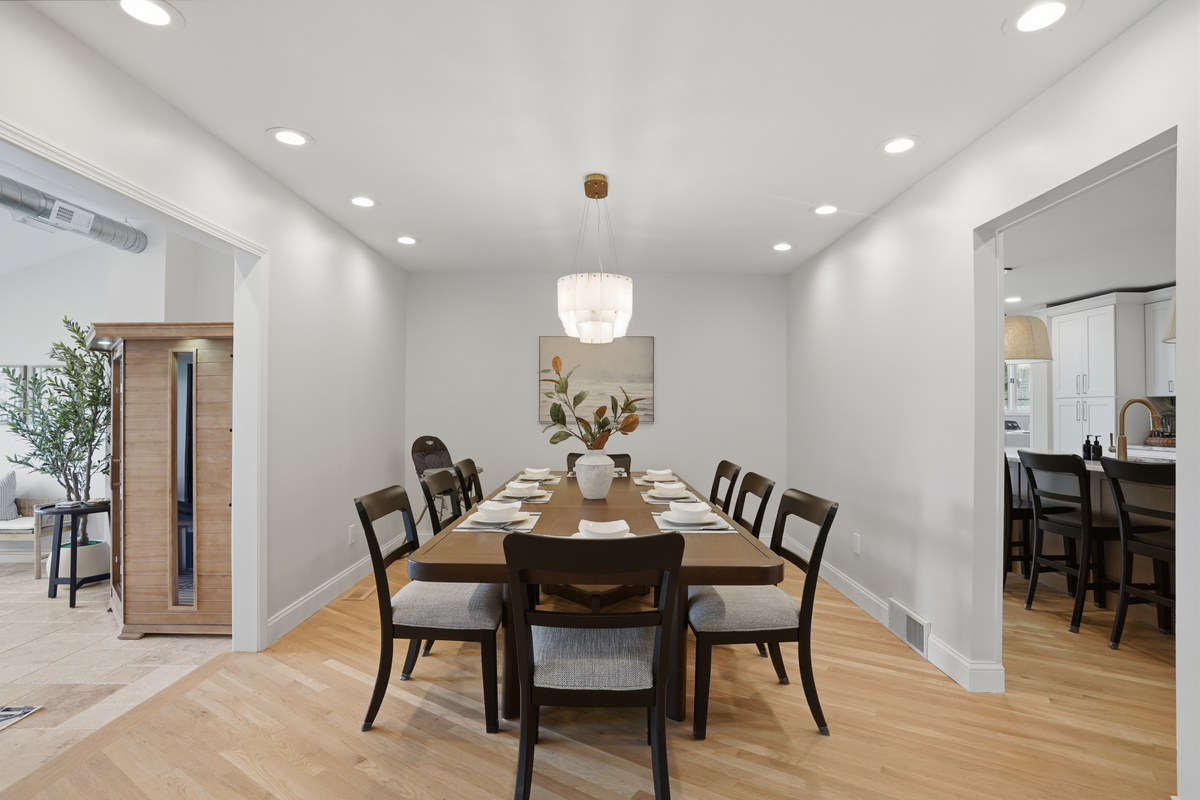 Elegant dining room with a large table, modern seating, and clean minimalist design. Bright, open space ideal for family meals, gatherings, and entertaining in a stylish, upscale setting.