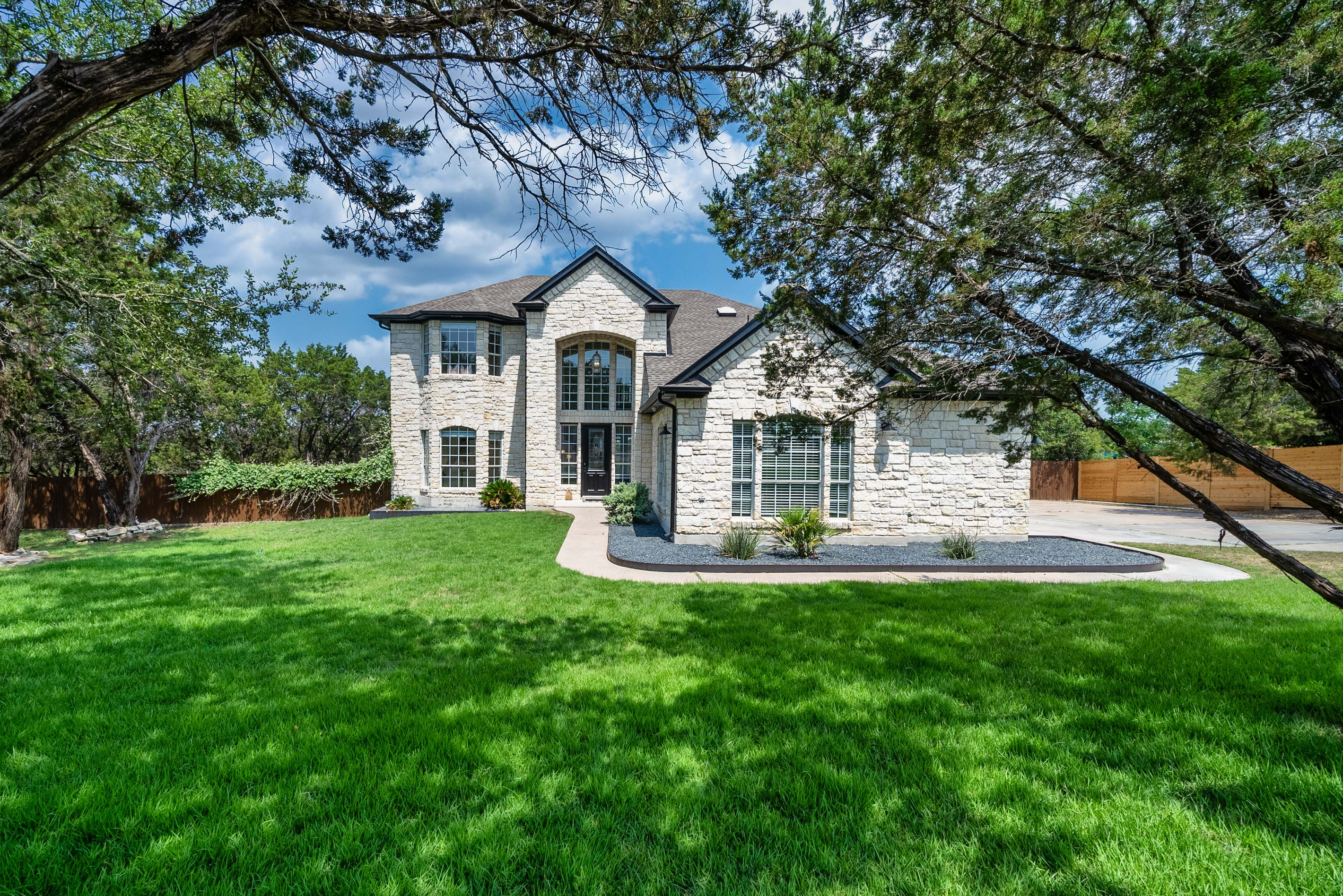 Grand stone exterior framed by a sprawling green lawn.