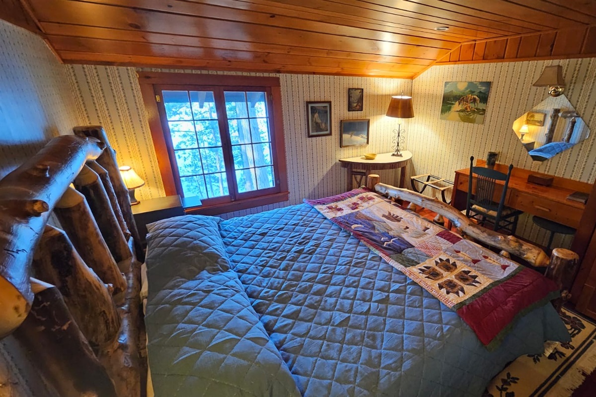 Second bedroom with king size bed, desk, and lake views.