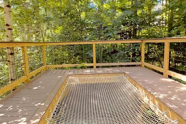 This unique treehouse deck offers a luxurious outdoor experience with an elevated hot tub and XL hammock seamlessly built into the deck floor. Additionally, enjoy the refreshing outdoor shower while surrounded by nature, making it a perfect retreat.