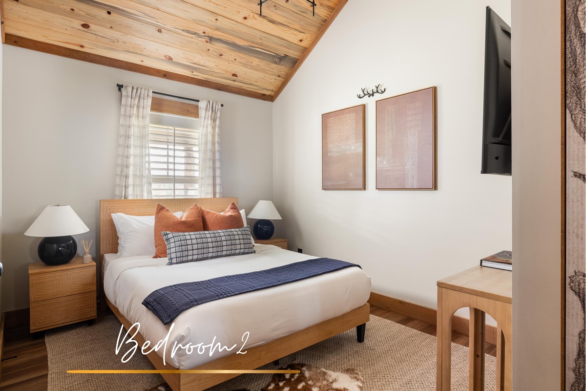 A queen bedroom wrapped in soft neutrals and a warm wood ceiling, cozy, inviting, and made for rest.