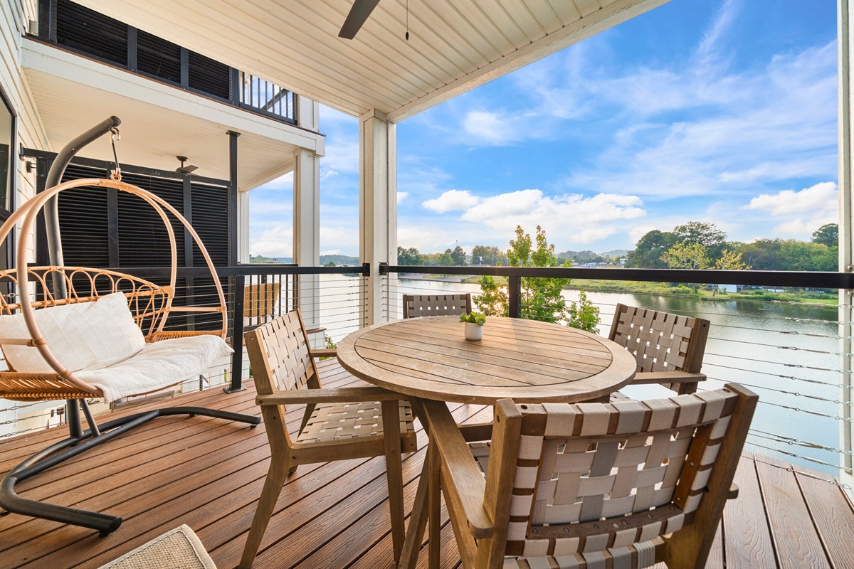 Covered patio with outdoor dining and peaceful water views.