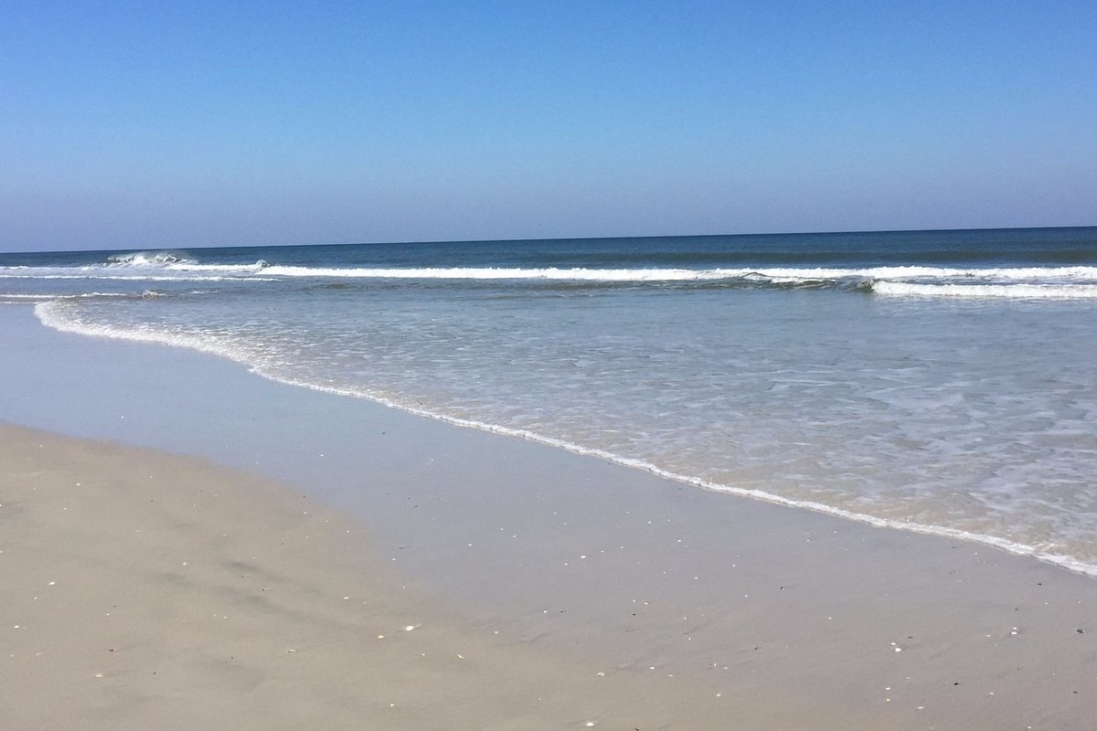 Gentle waves and a wide sandy shoreline