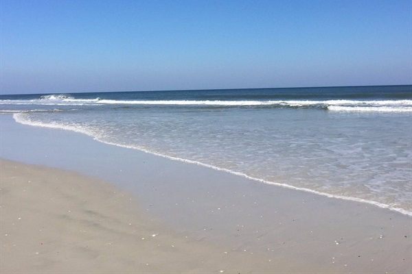 Gentle waves and a wide sandy shoreline