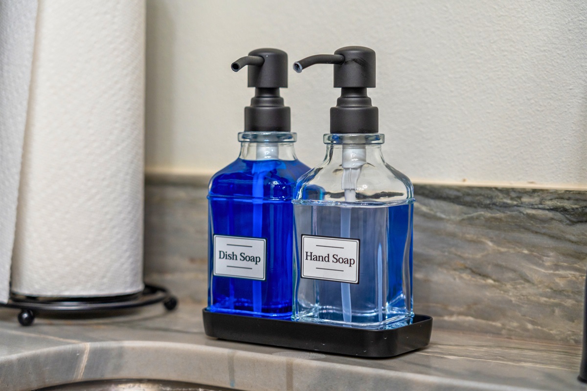 Sleek hand soap and dish soap dispensers keep the kitchen clean and functional while adding a stylish touch to the counter.