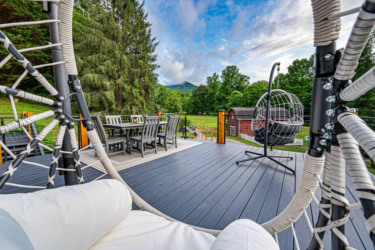 Relax on the expansive deck with mountain views and a stylish hanging chair!
