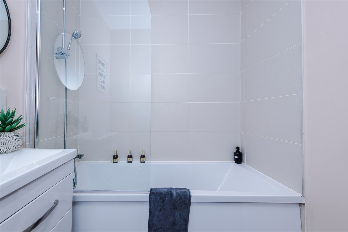 The modern bathroom benefits from a toilet, basin, shower & bath with shampoo & body wash on arrival