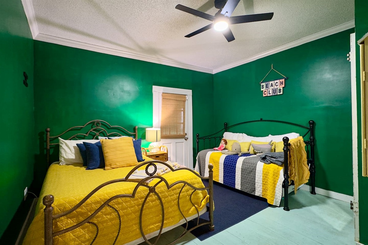 Cheerful sleeping space with dual beds, cozy linens, and a relaxed coastal feel.