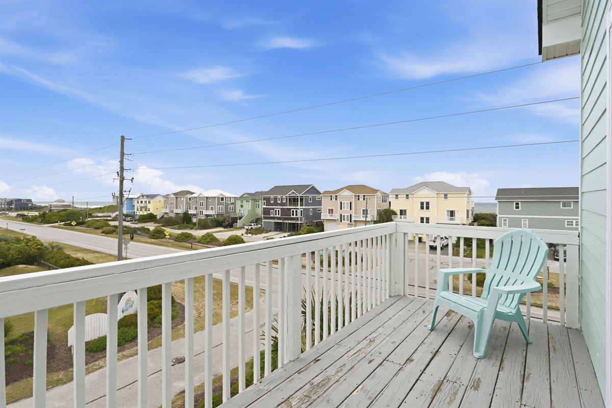 Corner deck with Adirondack chair and open coastal outlook
