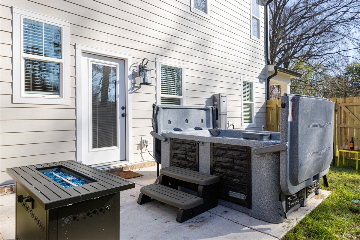 The hot hub and fire pit in the fenced back yard.