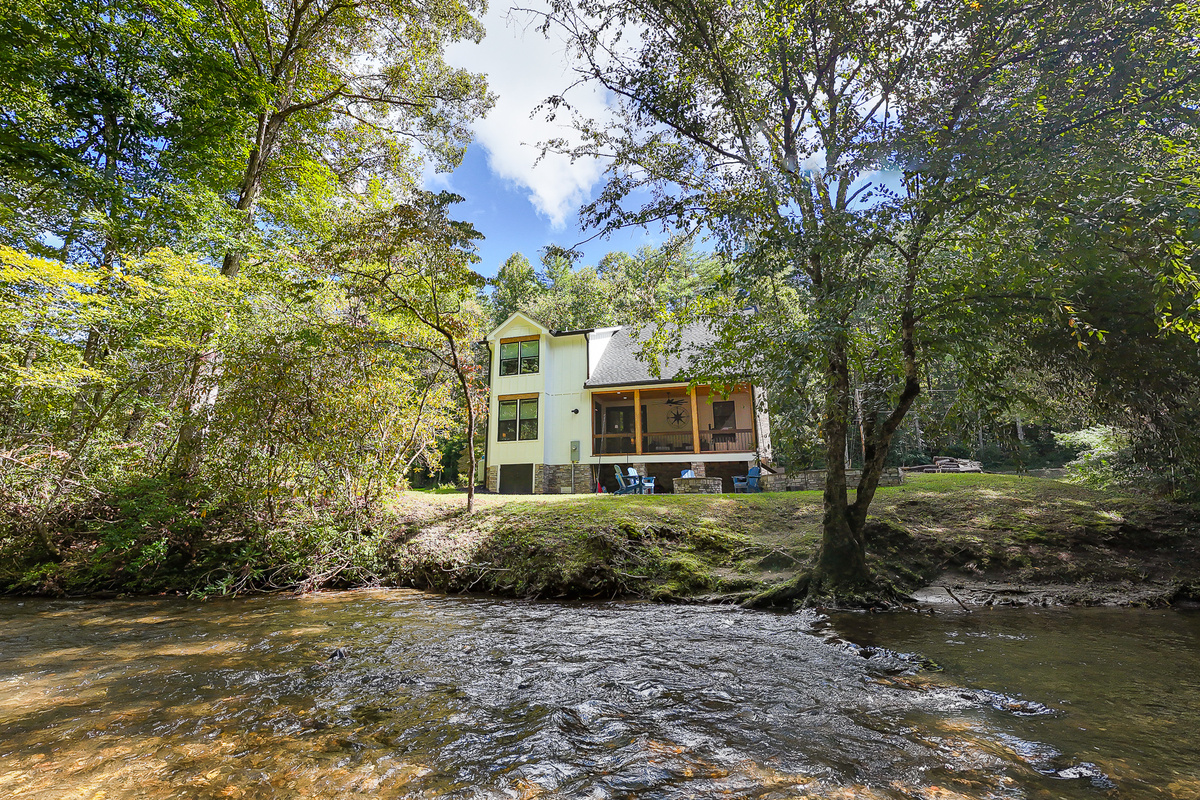 Robbin’s Nest on Snowbird Creek offers a peaceful waterfront setting, with a screened porch and outdoor fire pit overlooking the tree-lined creek.