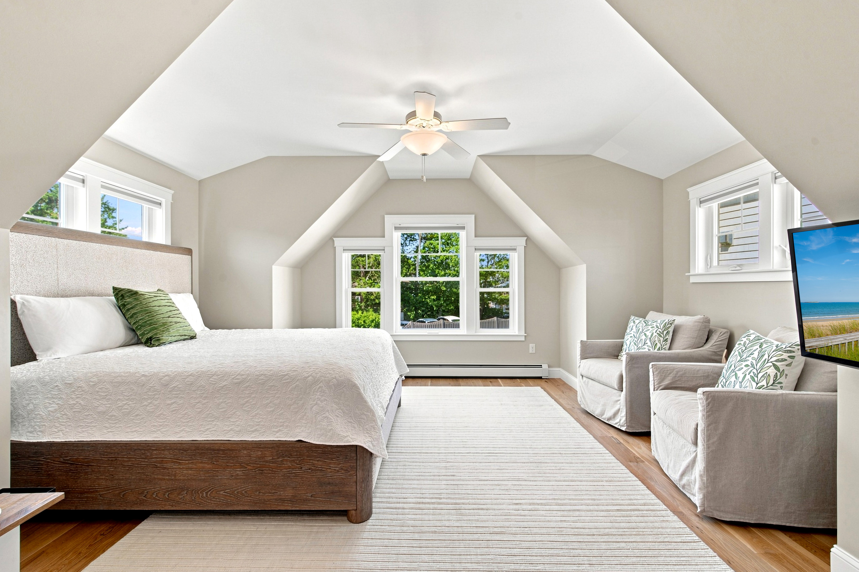 A spacious, light-filled bedroom offers a peaceful retreat with comfortable seating and plenty of room to unwind.