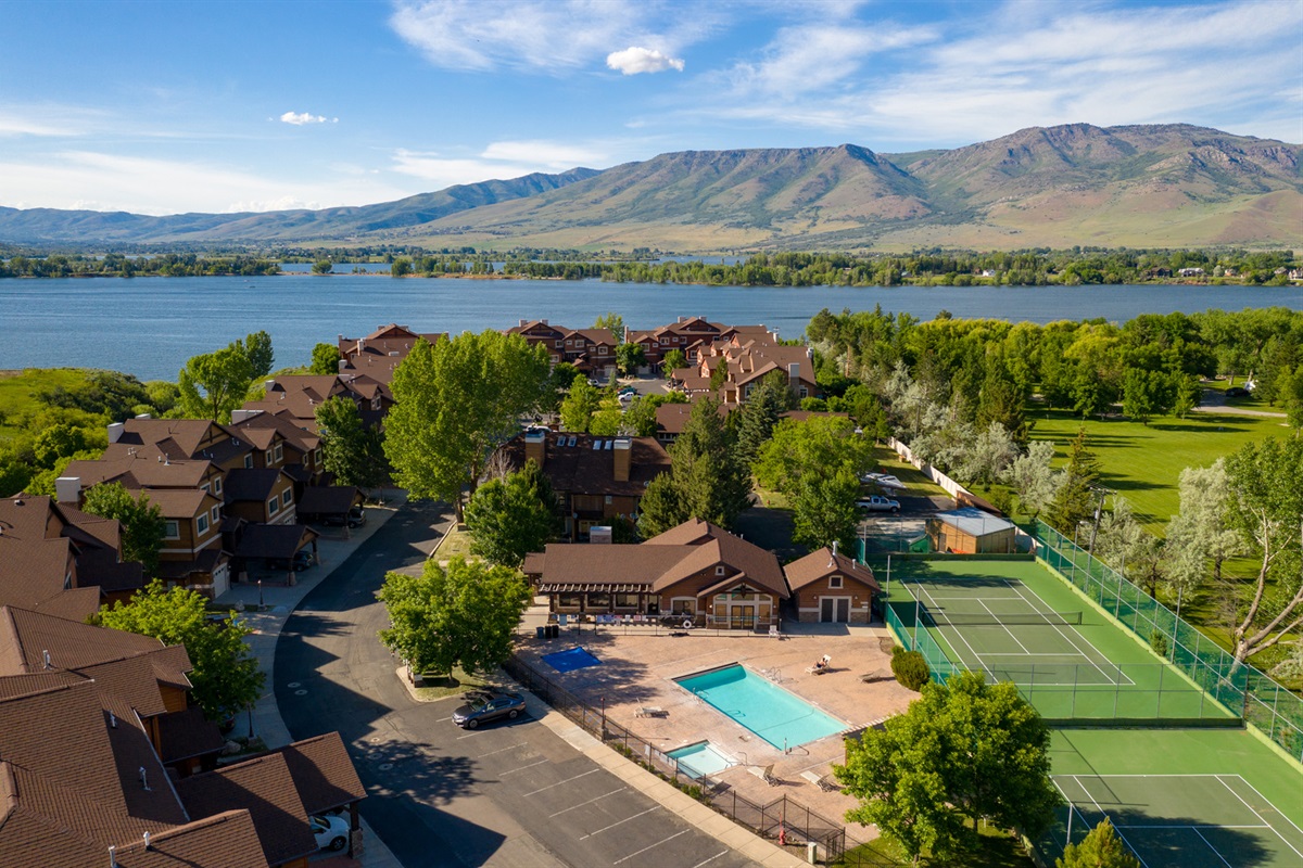 Aerial view of Lakeside Village showcasing resort-style amenities, pristine landscaping, and the stunning backdrop of Pineview Reservoir.