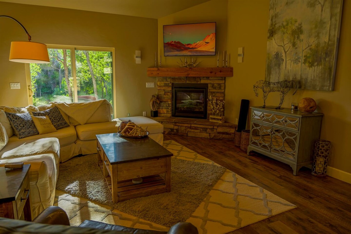 Living room with gas fireplace, flat screen tv, and access to spectacular outdoor patio space.