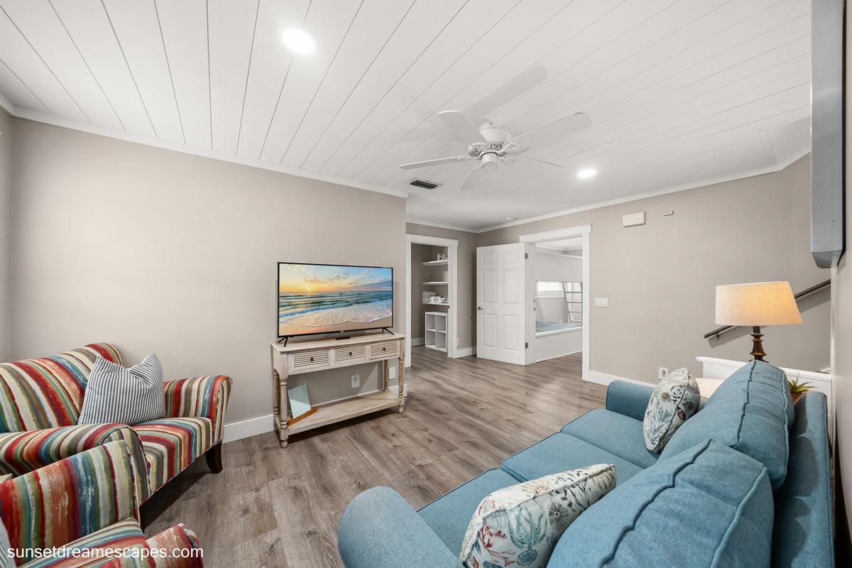 Secondary living room located in the rear of the home. Steps to the left lead up to the loft bedroom and second, upstairs bunk bed room. 