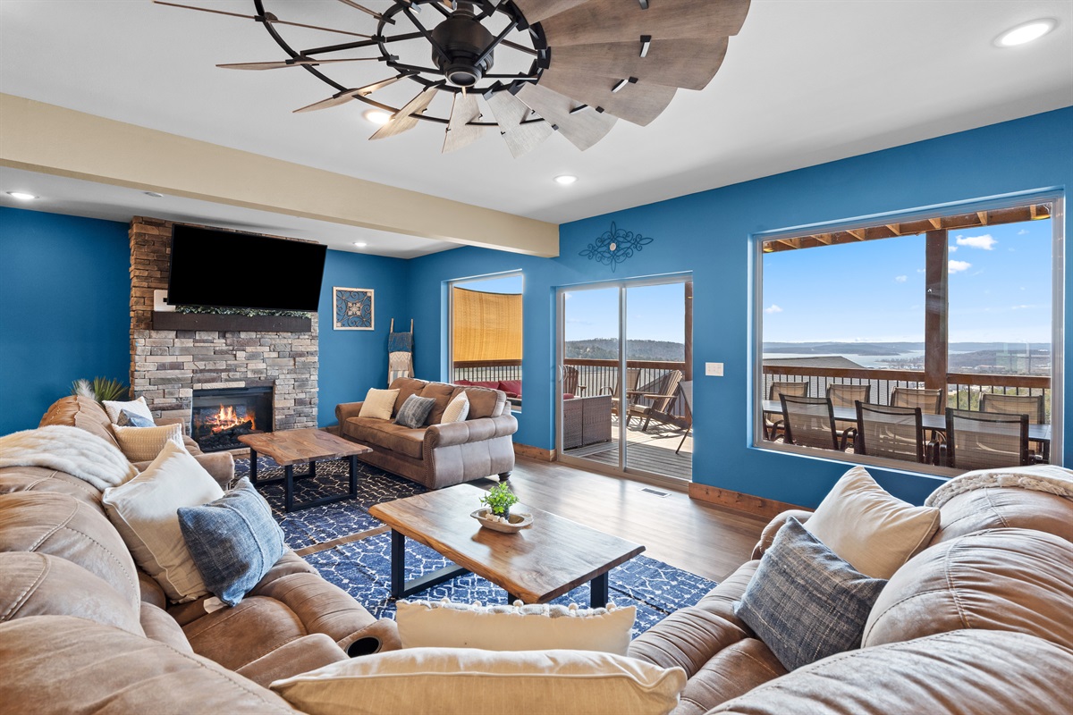 Spacious open-concept living area with cozy fireplace, large seating area, and access to the lake-view deck