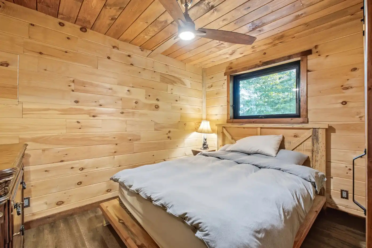 Cozy bedroom with warm wood-paneled walls