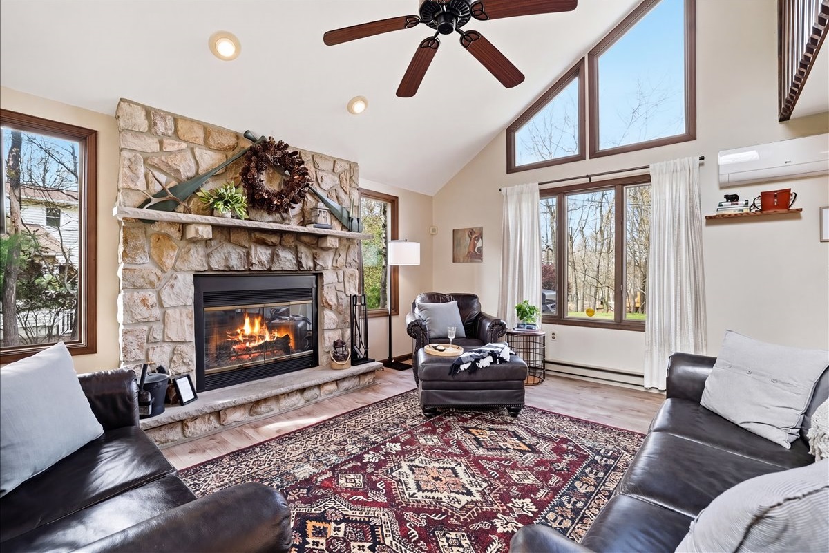 The soaring stone fireplace is the heart of the cabin. Light a fire, sink into the leather sofas and unwind in true Pocono comfort