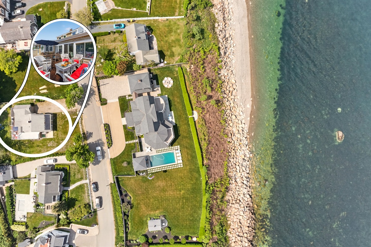 Aerial view of the surrounding area showing the property in relation to nearby homes, greenery, and streets, highlighting the overall neighborhood layout and accessible location.
