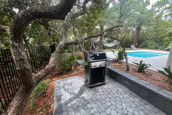 Full size gas grill conveniently located steps from dining table.