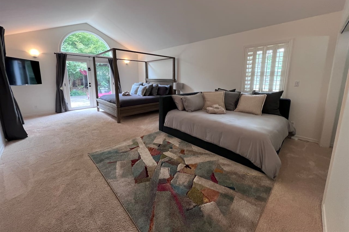 Primary Bedroom: California King bed with a Queen-sized daybed that can be used for lounging or sleeping. Private connected bathroom (en suite).Desk alcove with office chair. 55" 4K TV. Large walk-in closet.