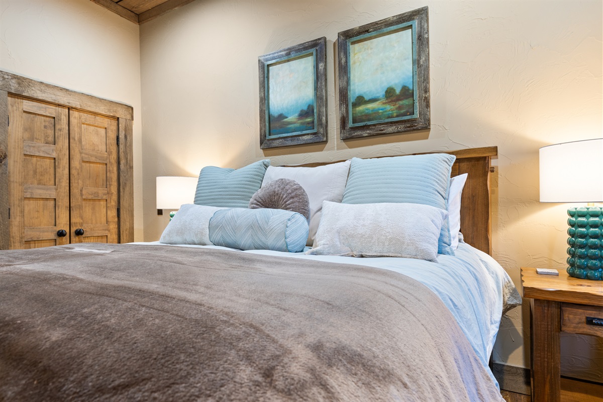 A serene bedroom retreat with plush bedding, rustic wood accents, and calming artwork for ultimate relaxation.