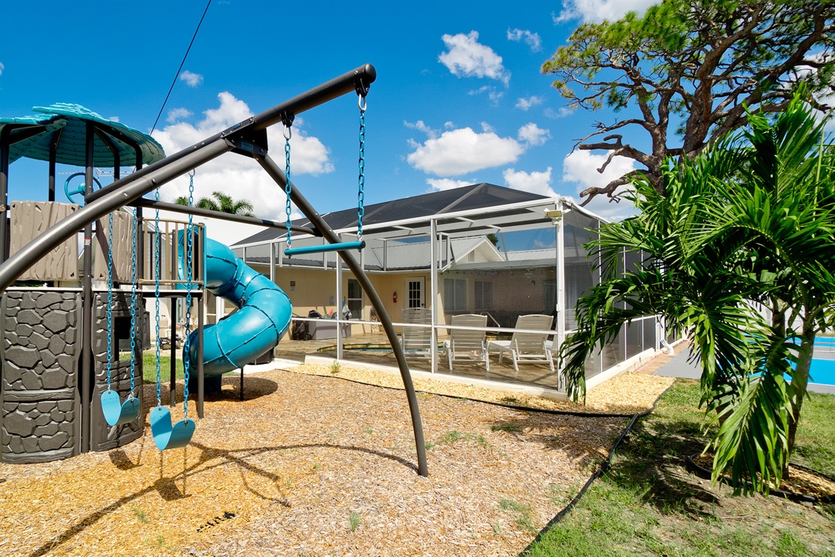 A backyard built for memories — the cheerful playset and sparkling caged pool create the ultimate setting for family fun under the Florida sun.