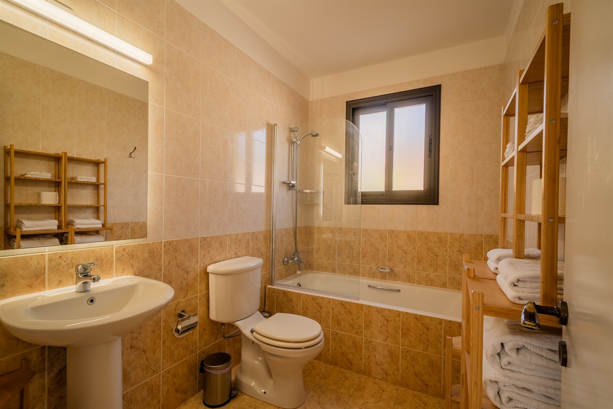 Full bathroom with bath tub and shower combo and heated towel rails. Situated in the hallway between the two king bedrooms.