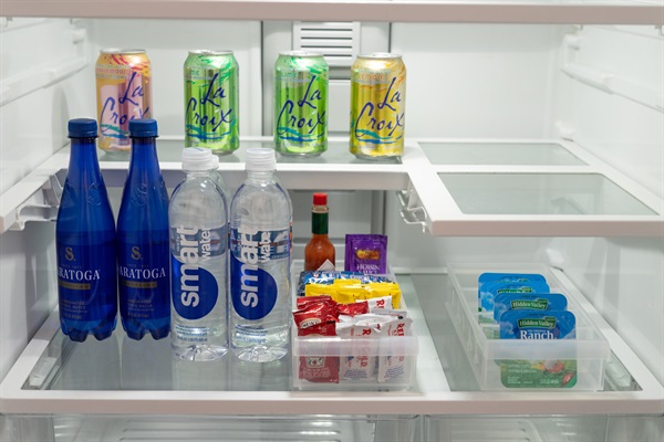 Refrigerator stocked with complimentary drinks and water