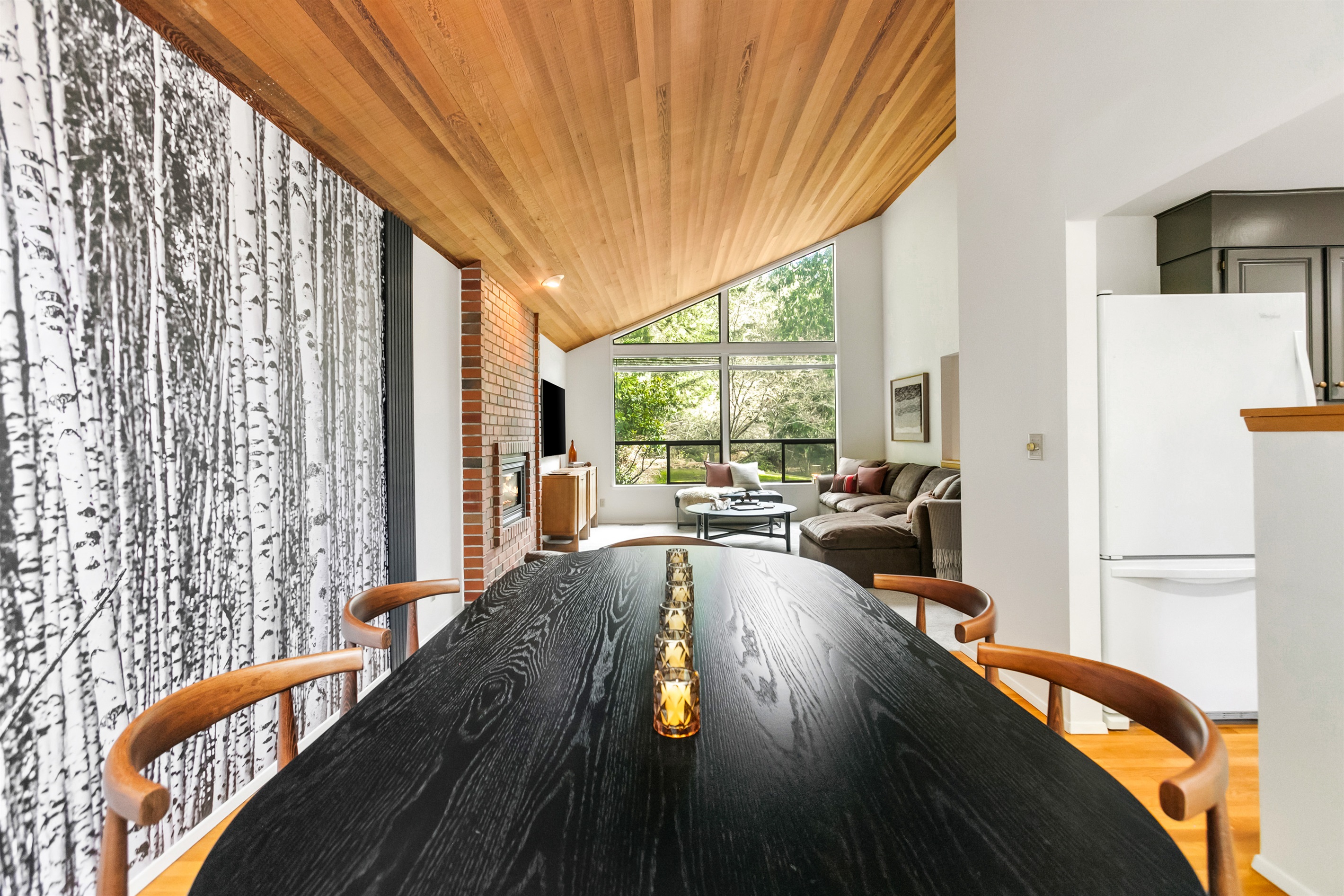 A striking birch tree mural and vaulted cedar ceilings frame the dining table, which can seat eight.