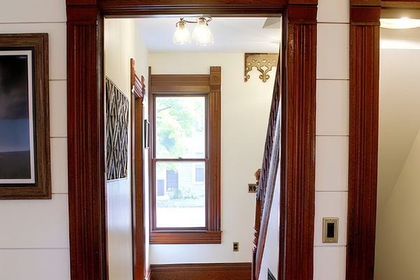Guests walk from chef’s kitchen down short hallway to staircase leading to upper floor