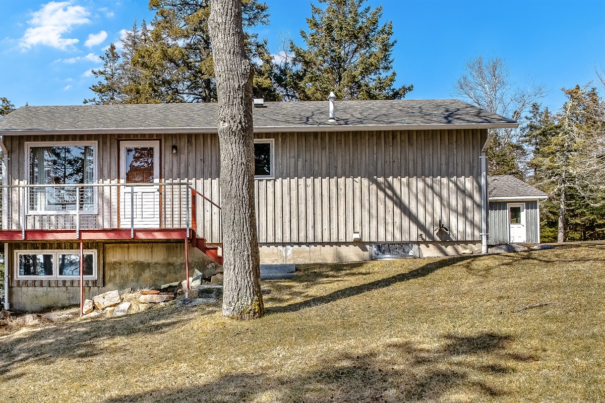"Space to Spread Out."
The expansive, wrap-around yard provides a rare level of privacy for the 'Quiet Side.' From this angle, you can see the distinct separation between the upper viewing deck and the lower-level garden suite.
