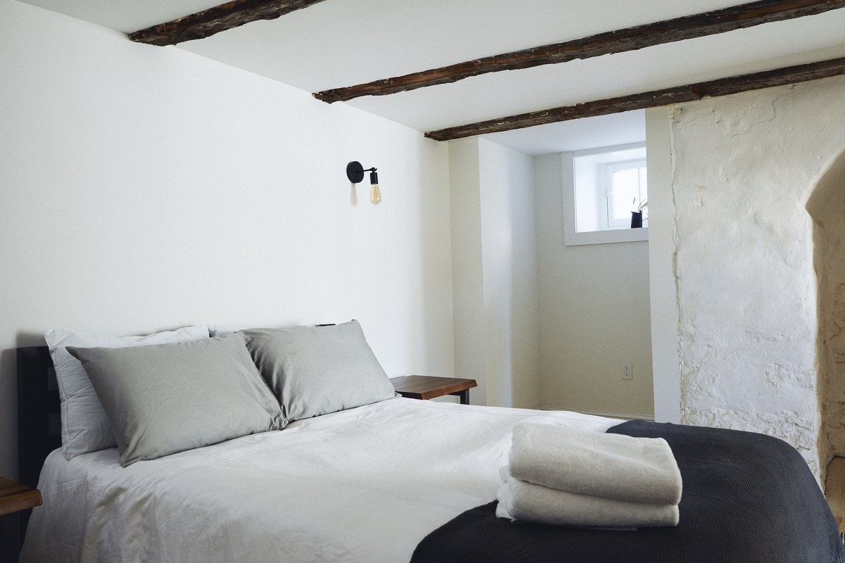 The queen bed under original beams