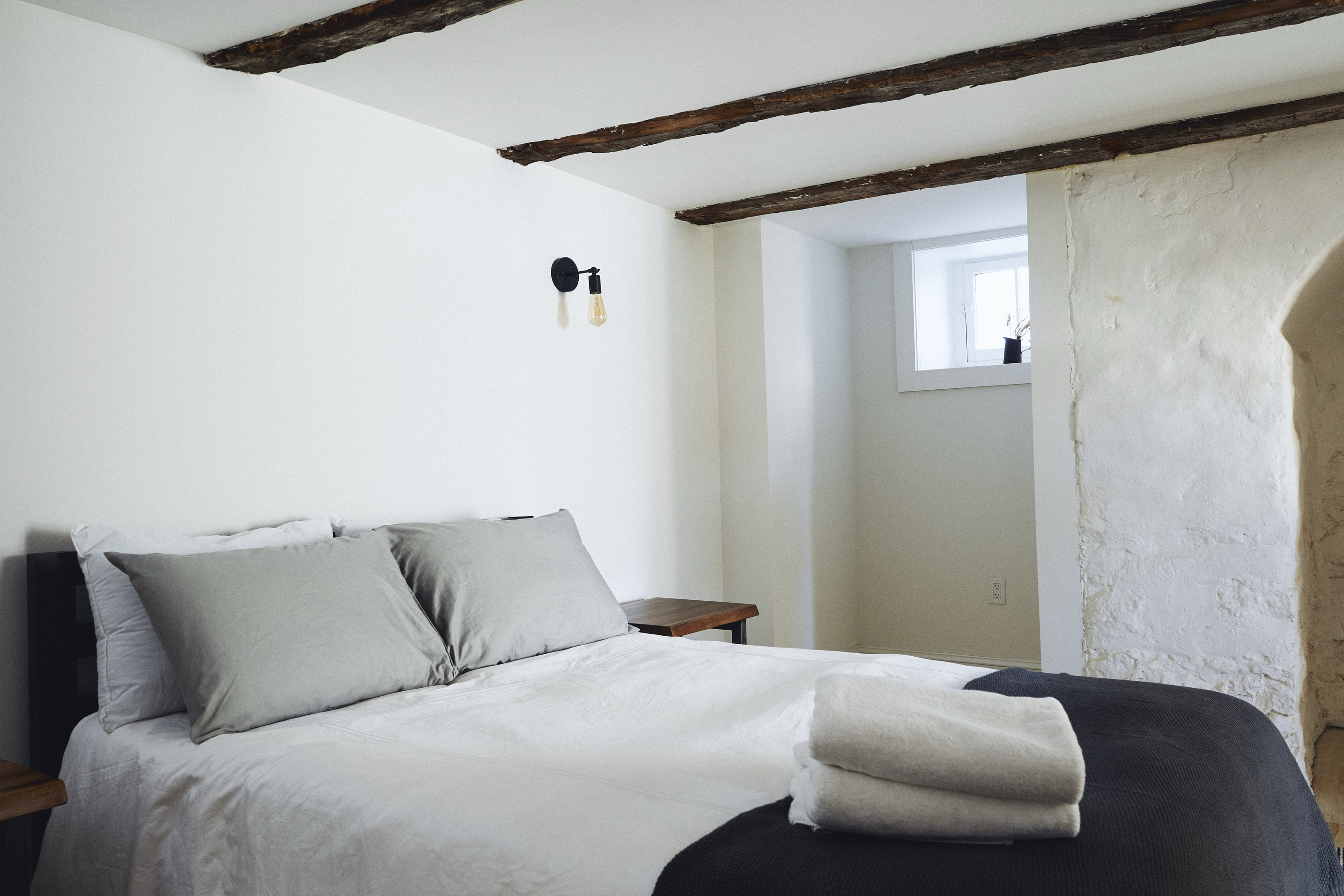 The queen bed under original beams