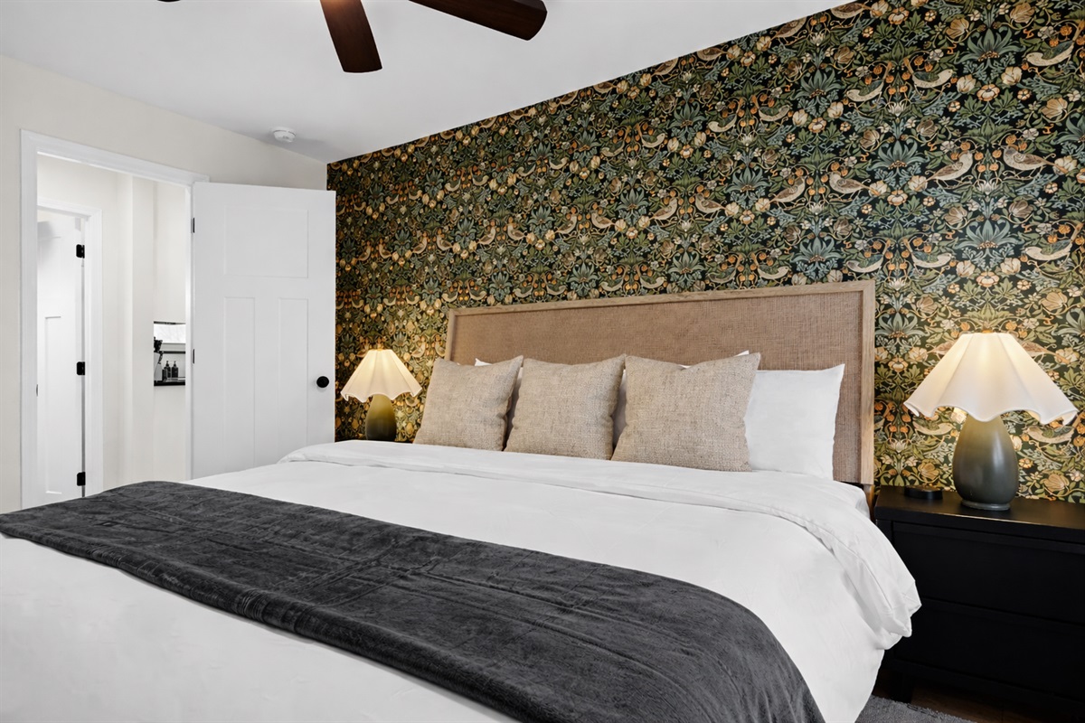 Rest easy in this stylish bedroom with a plush bed, warm lighting, and bold accent wall—designed for comfort, relaxation, and great sleep.