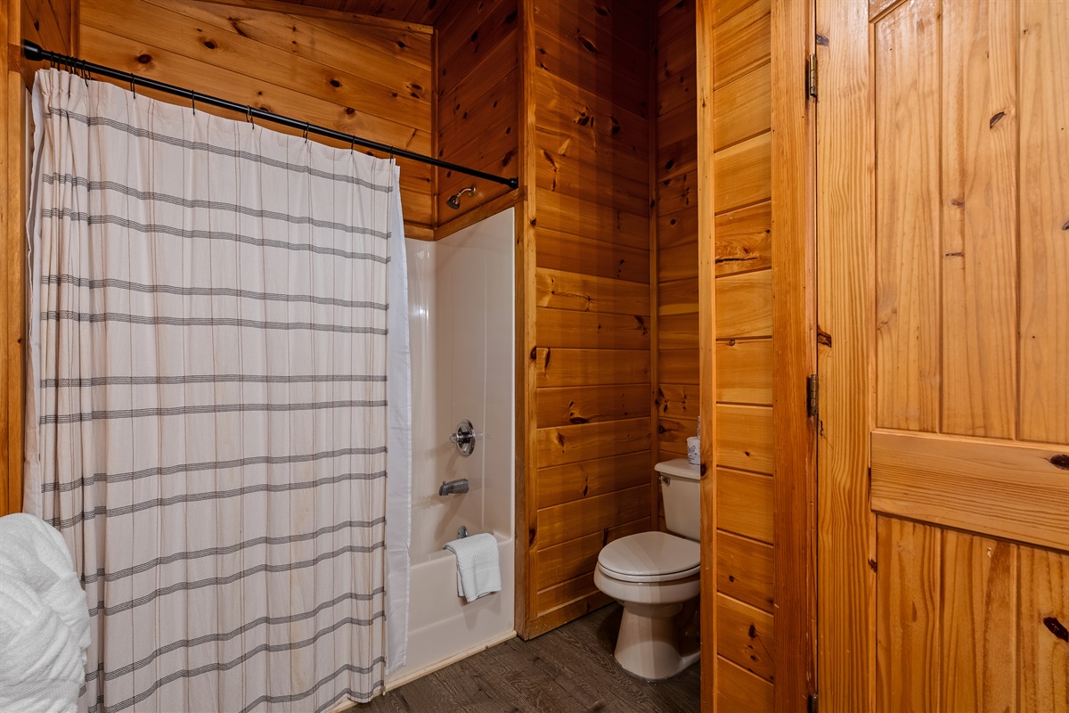 The main floor bathroom features a convenient shower/tub combo that’s perfect for both quick refreshes and relaxing soaks after a day exploring the Smokies.