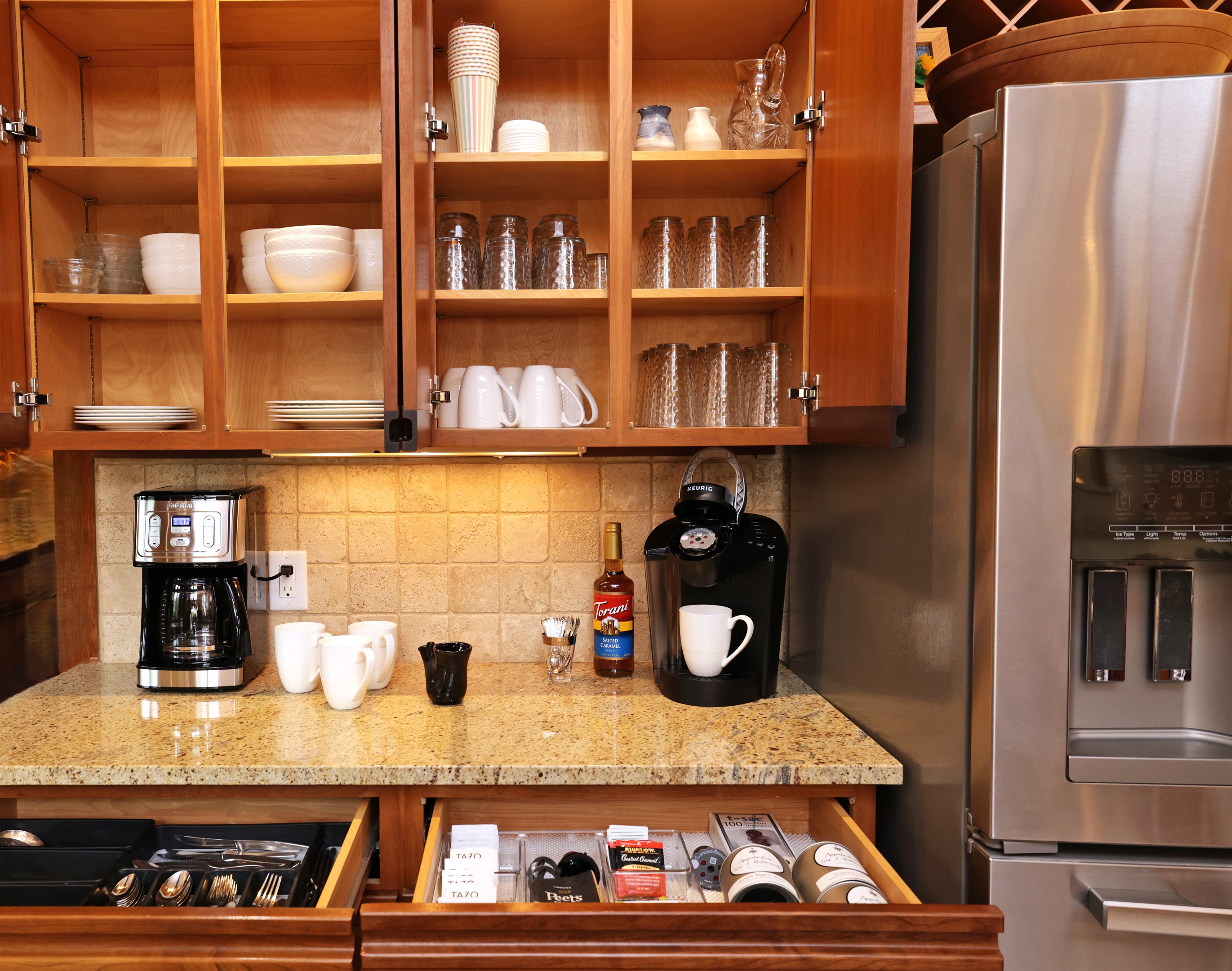Coffee and tea bar area with a drawer of tea selections and sweeteners plus Peets Coffee to start out your stay!  Dishes are stored above with 16 place settings (they are set up on dining table when this photo was taken!)