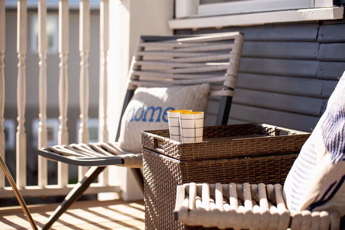 Chic relaxation: a balcony adorned with comfortable seating and a table, inviting you to enjoy the outdoors in style