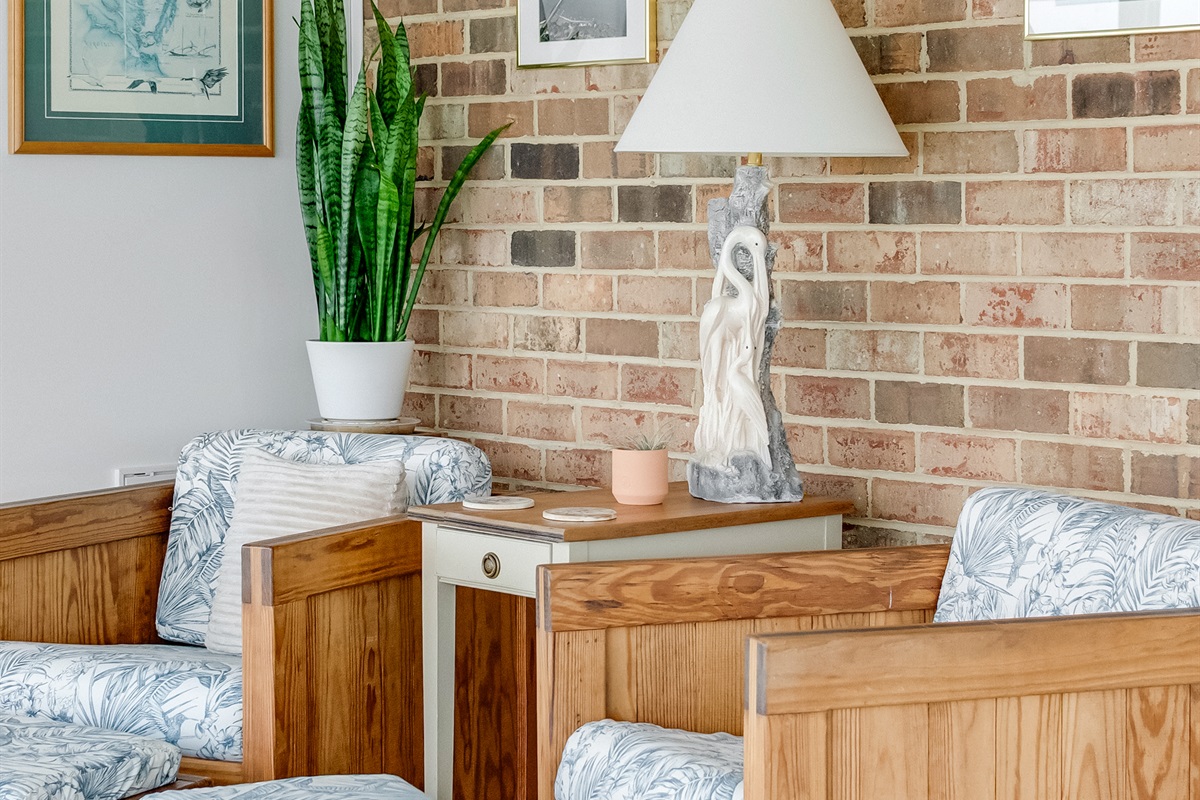 Living Room: Relax in style with vibrant decor, natural light, and a charming brick backdrop!