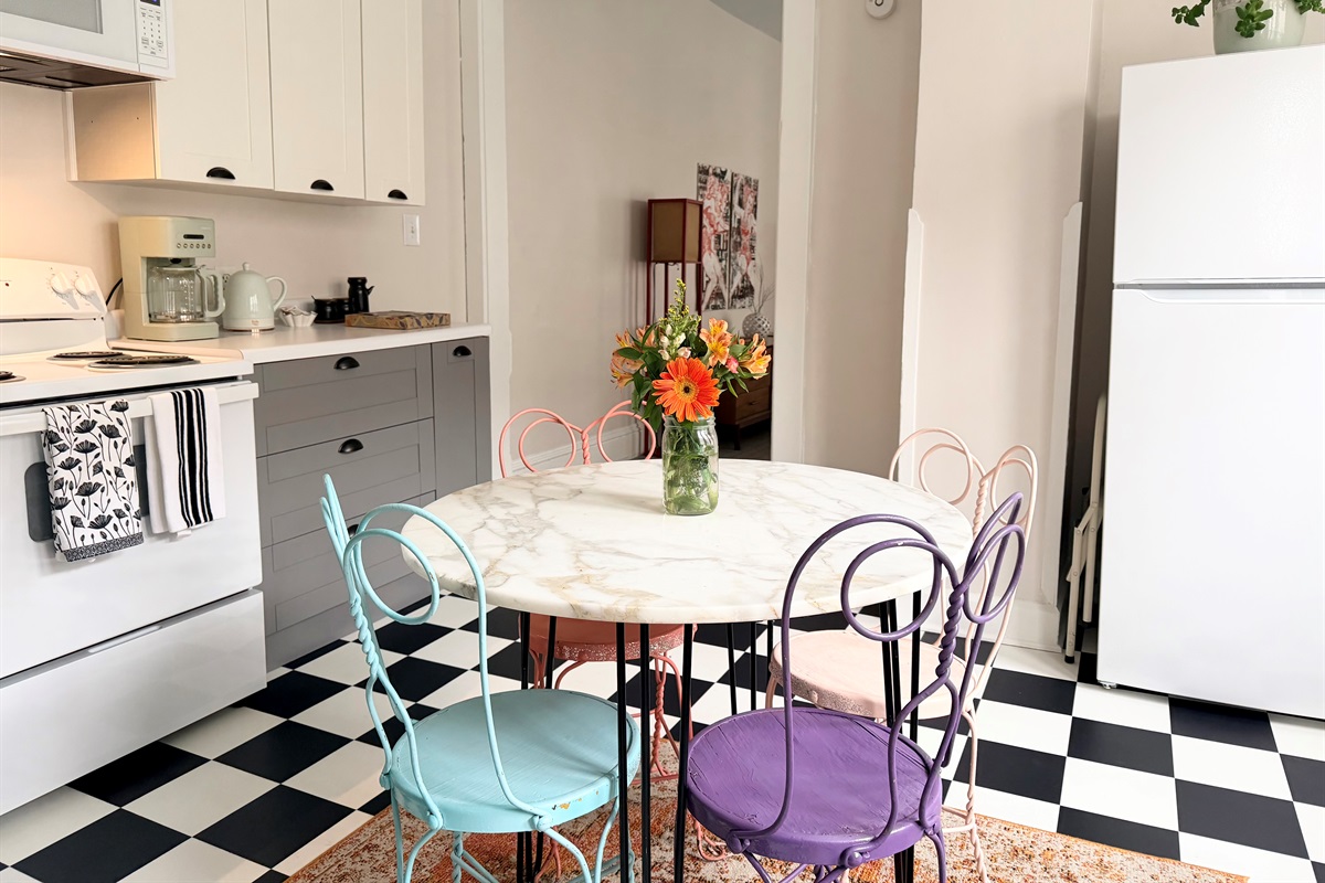 Fully equipped kitchen with full-size refrigerator, electric oven, essential small appliances and seating for four.