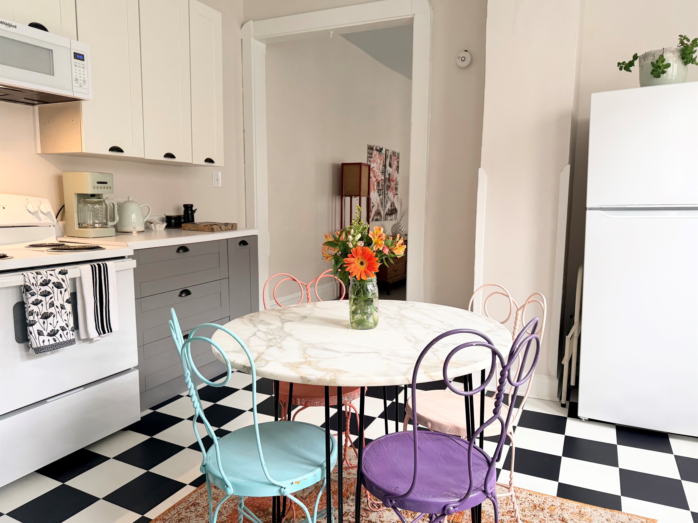 Fully equipped kitchen with full-size refrigerator, electric oven, essential small appliances and seating for four.