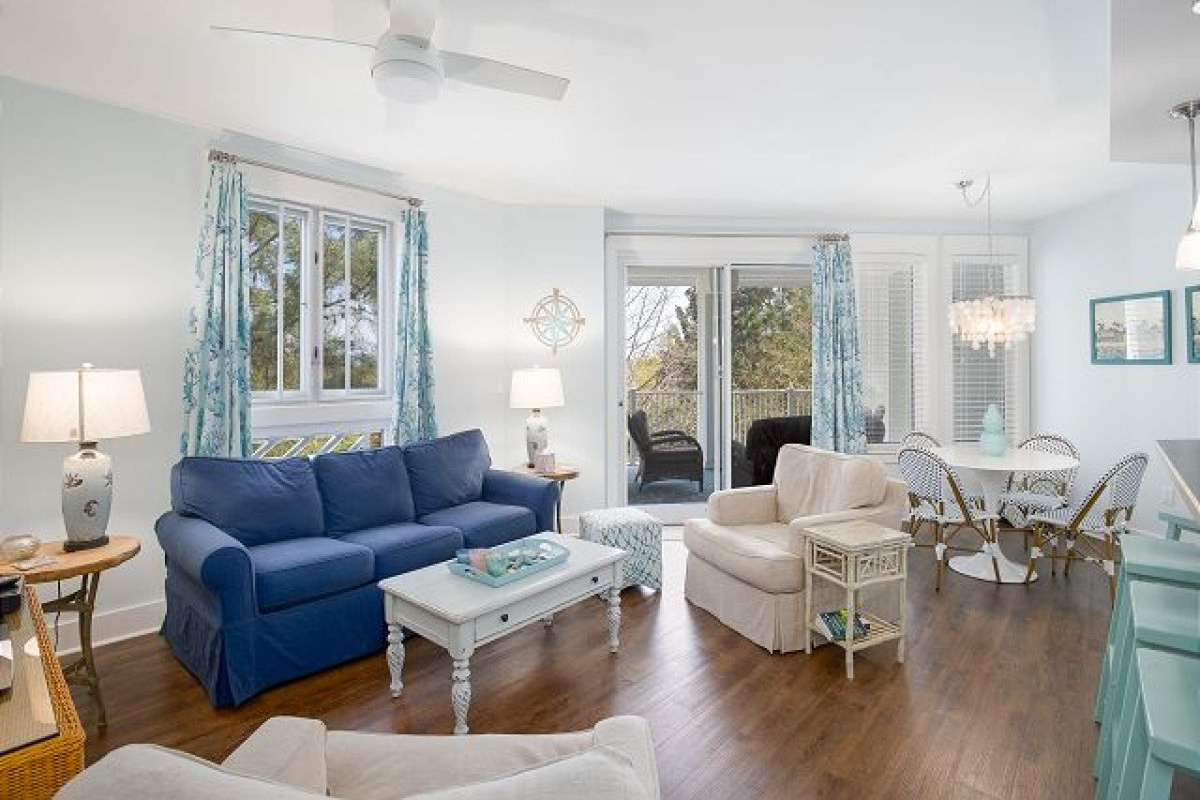 Living room with queen sleeper sofa, ceiling fan and sliding doors opening to the balcony