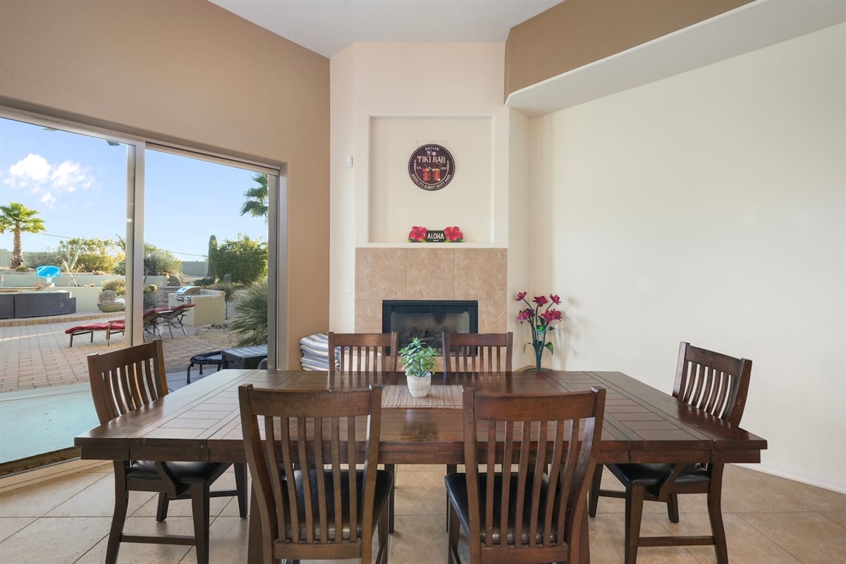 Dining table set beside the fireplace with seamless indoor-outdoor flow