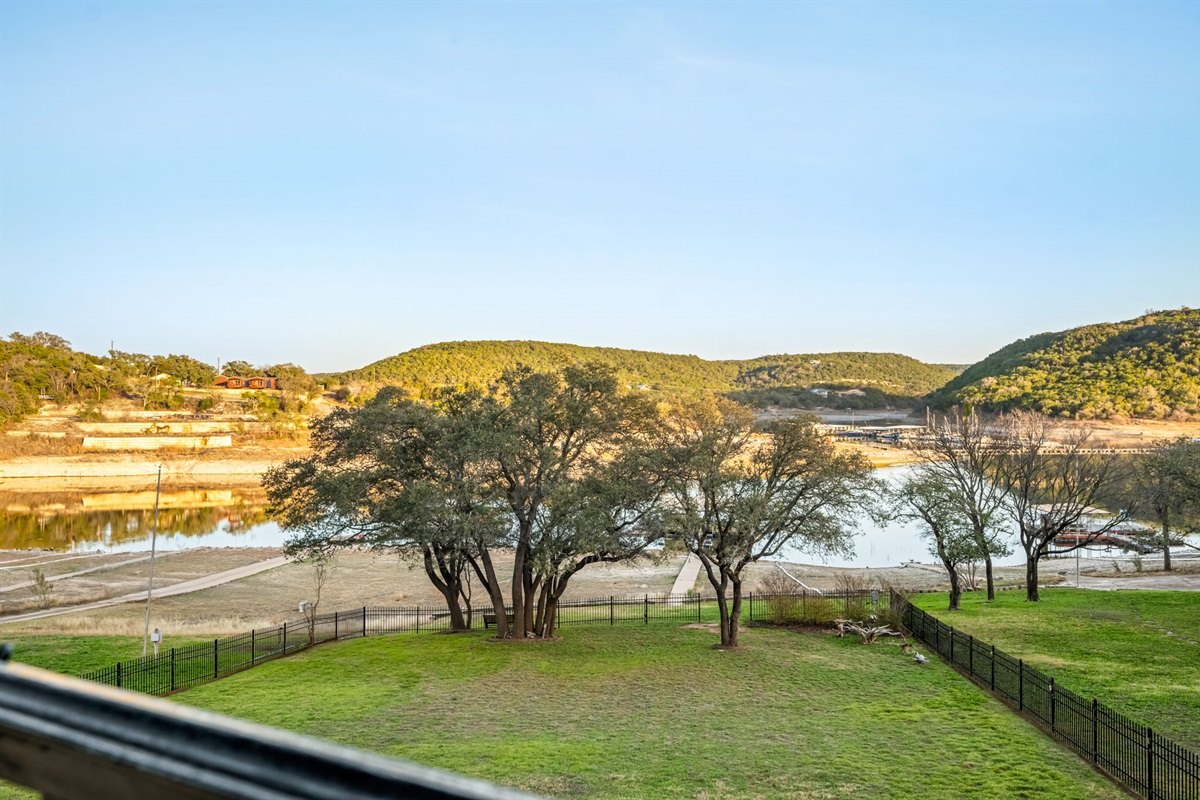 Peaceful backyard with open green space and beautiful waterfront scenery.